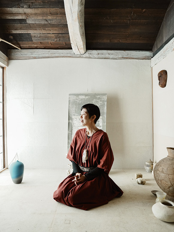 画像: 工房を案内してもらう平澤さん。加工室の2階は、壁にも床にも土を塗り和紙を貼った、温かみの漂う小部屋に