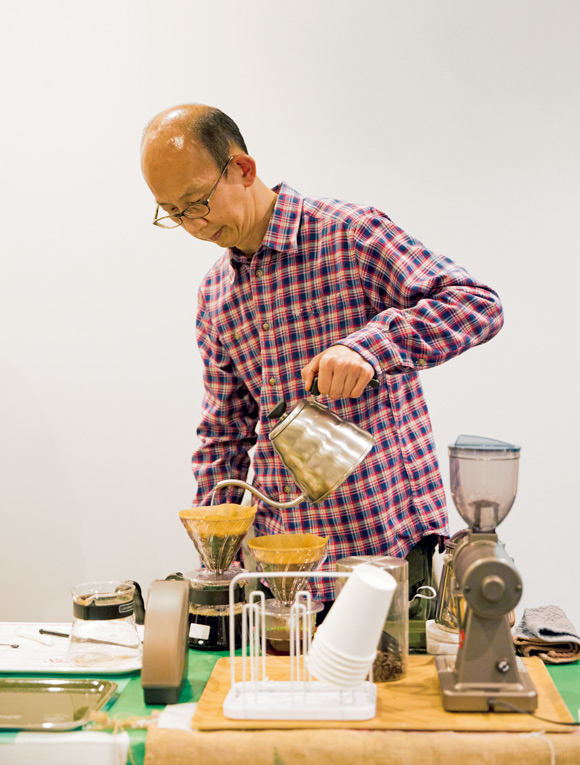 画像: 豆挽きからドリップまでの一連の作業を、動く左手のみを使い、丁寧に行う岸井和也さん。カップを返しにきたお客さんから「おいしかったー」と声が上がる