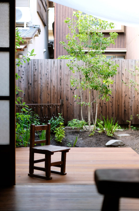 画像: 畳3畳ほどのウッドデッキは部屋となだらかにつながり、家にいながら緑を身近に感じられます。洗濯物を干したり夫がDIYをしたり、保存食づくりにも便利