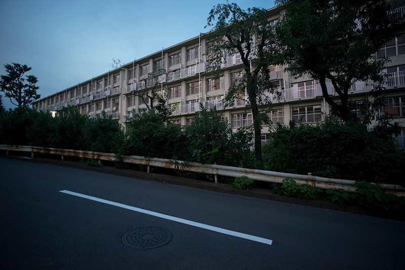 画像: 関根お気に入りの住棟がこちら。おそらくN-32号棟かと。よーく見ると、窓のレイアウトが不思議です。日没間際に撮影したので、薄暗くてスミマセン。2014年の撮影ですが、建て替えが決まっているためか空き部屋が目立ち、撮影時間とあいまってちょっと物悲しい雰囲気になっちゃっています