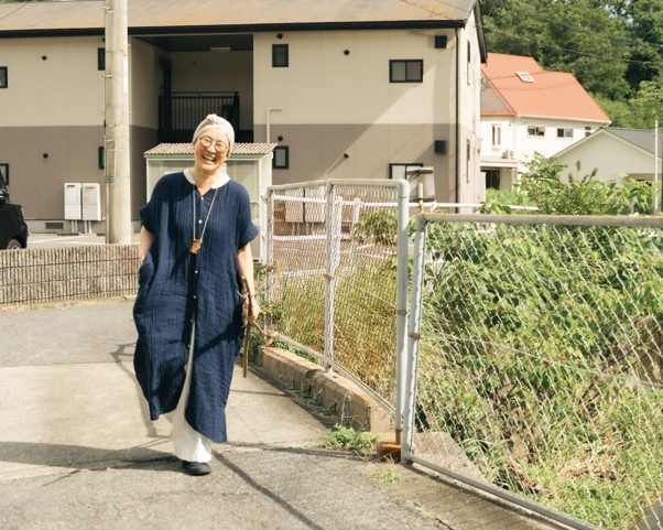 画像: アトリエ付近で植物を採取し、満面の笑みで歩くcafcaさん