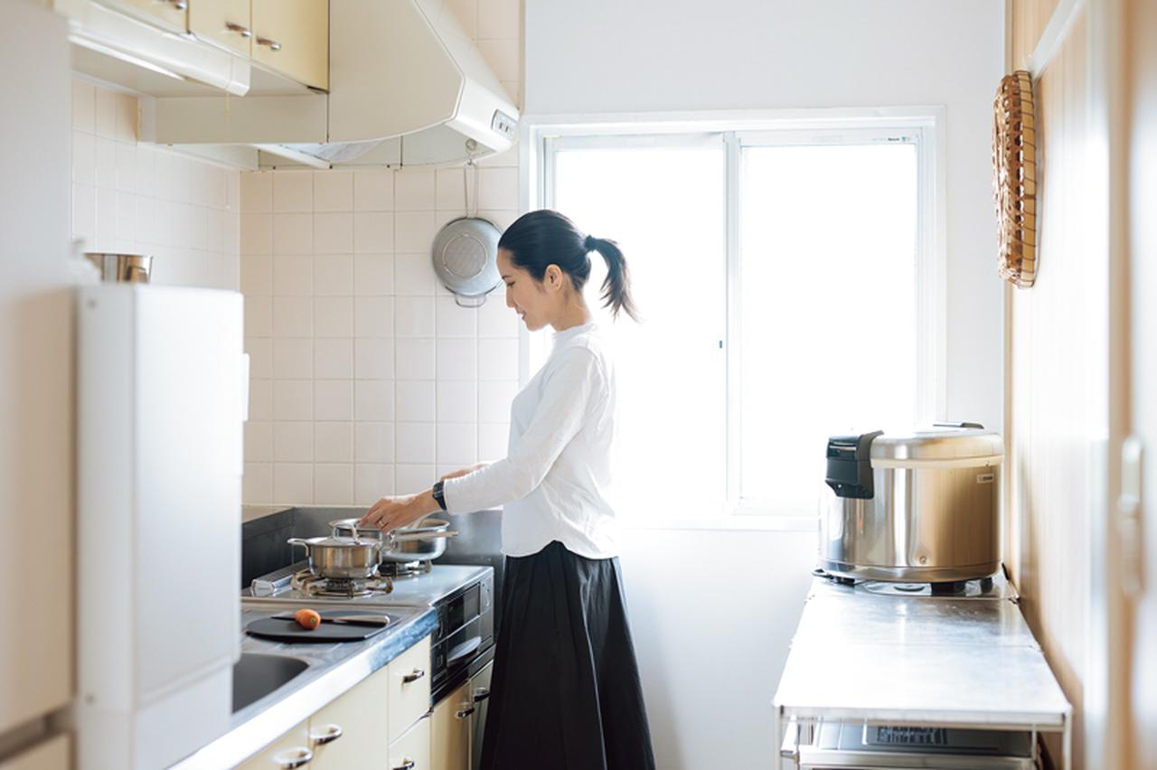 画像: 自然光が入る明るいキッチン。背面の「無印良品」のラックは作業台としても便利