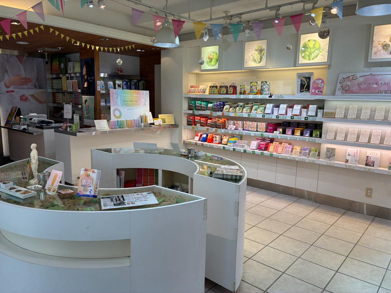 画像: 白を基調とした明るい店内。丸いお灸の台座をイメージしたカウンターが中央にあり、お灸が初めての人でも入りやすいオープンな雰囲気
