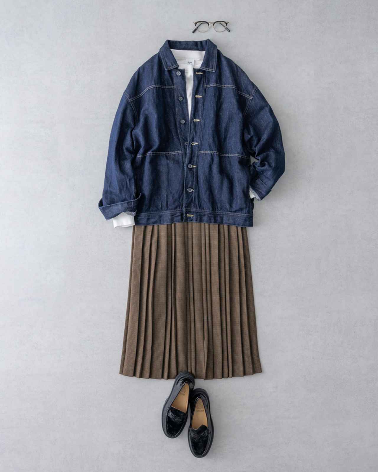画像: デニムジャケット 41,800円/ヴェリテクール 下に着たスウェット 10,780円/セムインターナショナル チェックのプリーツスカート 24,200円/コンジェペイエ アデュー トリステス メガネ 58,300円/イーファイブ アイヴァン(トリップ ルミネエスト新宿店) ローファー 23,980円/アストロサノス(セムインターナショナル)
