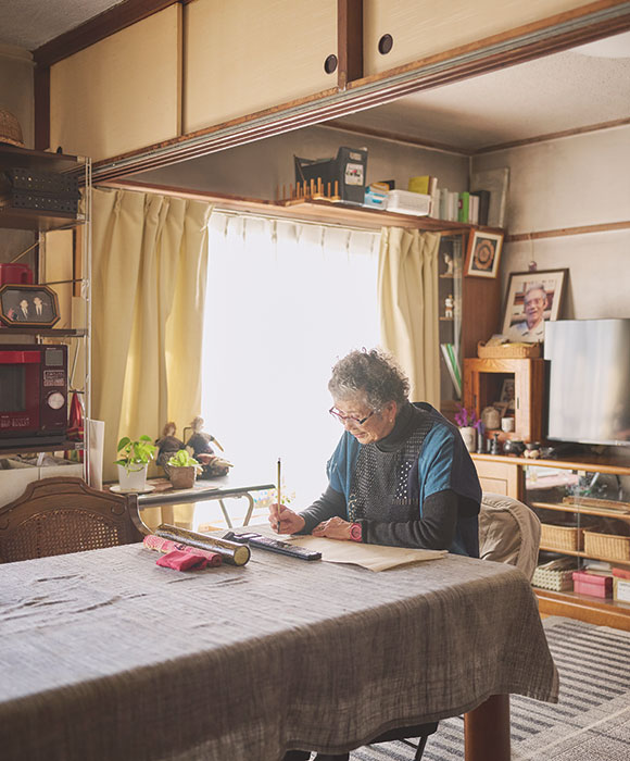 画像: 般若心経を読み上げたら墨をすり、薄めの紙をお手本に重ね、紙の上から筆で2時間かけてなぞっていく