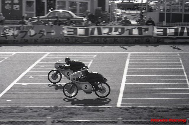 画像: 1965年最終戦となった日本GP(鈴鹿サーキット)50ccクラスで、1-2フィニッシュを決めたL.タベリ(奥)とR.ブライアンズ(手前)。この年のRC115(2気筒DOHC4バルブ)は13.6ps/20,500rpmという最高出力を誇り、ブライアンズとタベリの2人が7戦中5勝という好成績を残しました。 www.honda.co.jp