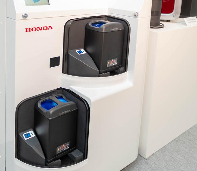 画像: こちらが実証実験に使われた充電ステーション。上下段それぞれに4本ずつが収納され、常時充電されています。