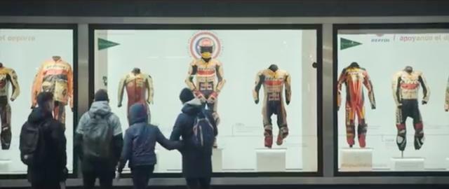 画像: 舞台はスペイン・マドリッド・・・ショーウインドウに、GPライダーたちが着用したレザースーツなどが陳列されています。 www.youtube.com