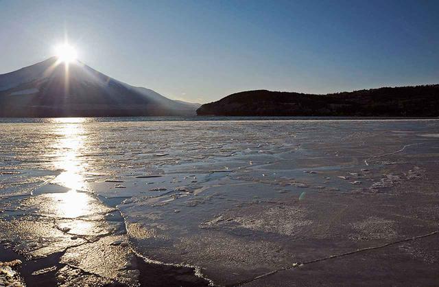 画像: 山中湖に張った氷に光の矢を放つ、夕暮れのダイヤモンド富士。