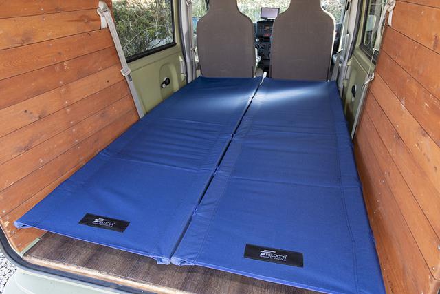 画像: 親子で車中泊キャンプに行くことも多いという。そのときは室内にキャンプ用のコットを2つ置いて、フラットな床を作る。偶然にも、コットのサイズがクルマの荷室と同じサイズだった。