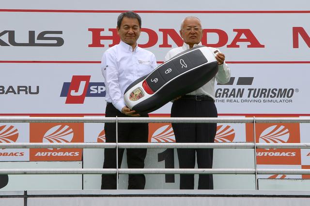 画像: ポルシェジャパンの七五三木敏幸社長(写真左)からカイエンSのカギを受け取るGTアソシエションの坂東正明代表(写真右)