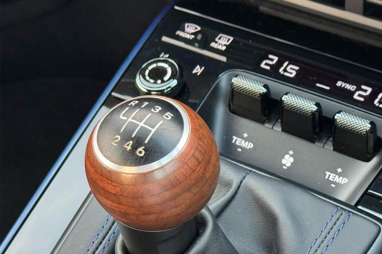 画像: 992.2型のCarerra Tでは、オープンポア仕上げのウォルナット積層木材のシフトノブが採用される。