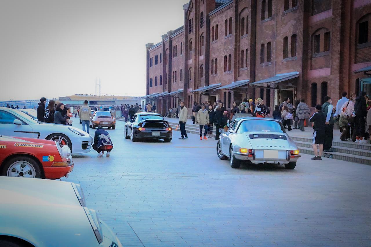 画像: 17時にイベントが終了となり、1台ずつ帰路につく。まだまだ来場者が多い時間帯であり、全車ハザードランプを点灯させつつ微速で移動。安全確保のため、ボランティアのスタッフが出口まで誘導する。