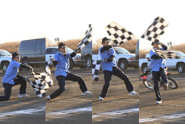 画像: FEVHOTSが誇るメインフラッガー: 和田真。本場American Flat Track Seriesで当代一の、つまり世界最高のフラッグマン、ケヴィン・クラークをして"日本で最も美しくチェッカーフラッグを振る男"と言わしめた。長身の和田が繰り出すドラマティックな旗捌きもまた、我々のショウの重要な要素のひとつ。撮影: 齊藤孝(FEVHOTS81)