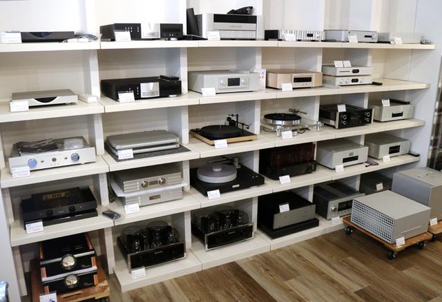 画像: 試聴位置後方の壁には一面にラックが設置され、各種機器が展示されている。デンマークのハイエンドブランド「Bergmann」の動きがいいそうで、その他にも、独「EINSTEIN」、米「Dan D’Agostino」なども普通に置かれている