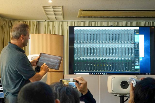 画像: (奥のディスプレイで表示されている)PC上で動作するTotal Mixを、iPadアプリ「Total Mix Remote」で操作しているデモ風景。操作は、ドイツRMEから来日した同社創業者で開発者のマティアス・カーステンズ氏