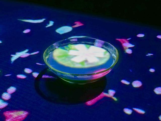 画像: 施設内の喫茶店でもプロジェクターが活きる。グラスに追従して、中央に花が咲いていく
