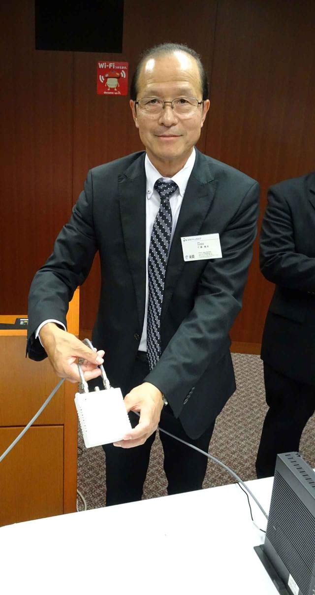 画像: 専用アダプターを手にするスカパーJSAT 仁藤雅夫 取締役 執行役員副社長