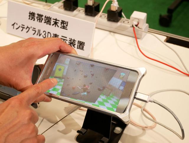 画像: ▲インテグラルシール(?)を貼ったスマホで、裸眼で3D映像が見られる、というデモ。指でスワイプすると、映像の角度(見え方)を動かすことができる