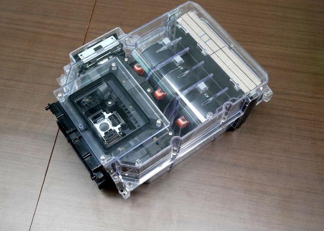 画像: 密閉化した光学ブロックの模型。中央に三つ並んでいる円柱形のものがファン。映像(光)は、左下に向かって投写される