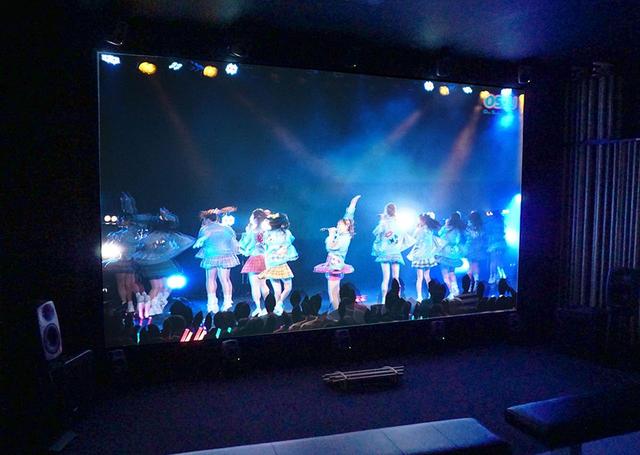 画像: スクリーン&22.2chスピーカーで8K/3D映像を再現していた。女の子たちのきらびやかな衣装のディテイルもきちんと再現できている