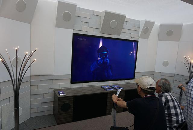 画像: 受付横の22.2ch体験コーナーには8Kディスプレイを中心にインウォールスピーカーがセットされている