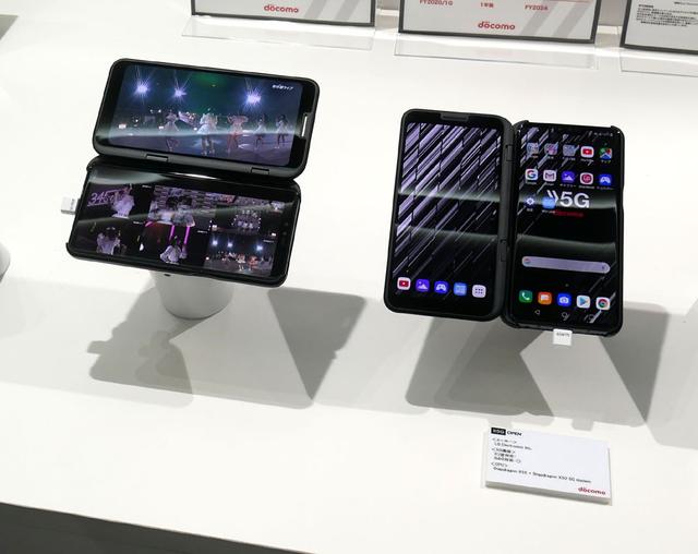 画像: ▲NTTグループブースでは、5G通信に対応した製品(スマホ)の展示や、5Gを使った新しいコンテンツ配信デモ(アイドルライブや、スポーツ中継【デモは先日のラグビー】のマルチアングル配信)を行なっていた。写真はLG製の2画面スマホで、横位置で使うと上部にメイン画面、下部にマルチ画面が楽しめます、というデモ