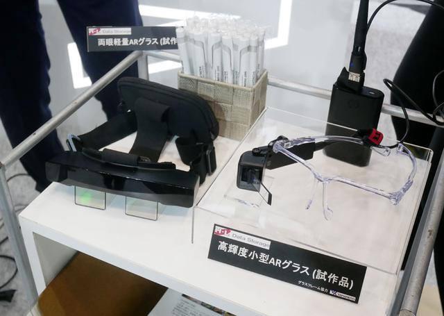 画像: ▲日立ブースでは、2種類のウエアラブルデバイスを展示。片眼用は輝度が高く(5000カンデラとか)日中屋外での使用も可。両眼用は、長時間の使用を想定しており見やすさを重視しているそう