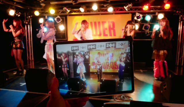 画像: ▲少し分かりにくいが、奥はリアルステージ。手前はTECH LIVE処理を行なったタブレット画面。ZOCメンバーの上部にバーチャル映像が描画されている