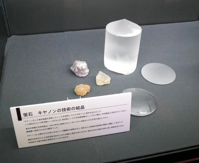 画像: ▲広報一押しが、蛍石レンズの展示。人工蛍石結晶採用レンズの発売から50周年ということで、あまり見ることのない大きな結晶(原石?)の展示も行なわれていた