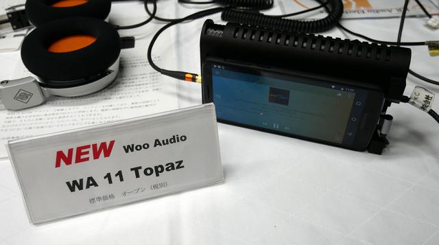 画像: ▲WOOオーディオのヘッドホンアンプ「WA11」。価格はオープンで想定市場価格は¥250,000前後。管球式の「WA8」に対し、本モデルは半導体を採用し小型を図ったという。クラスAで動作し、内蔵バッテリーで約6時間の駆動が可能。ESS9018M DACを内蔵し、384kHz/24bit、DSD5.6MHzの再生に対応する(写真のスマホは付属せず)