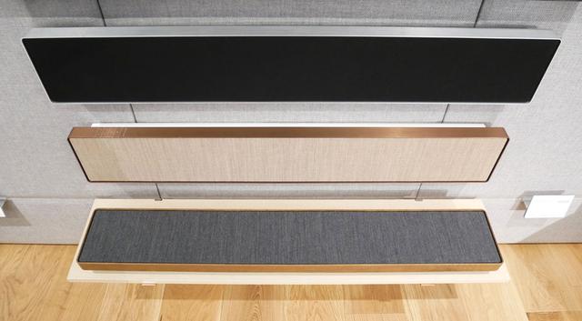 画像: ▲いわゆるサウンドバーのBEOSOUND STAGEは、店舗奥の右側の壁に設置。一番上のシルバーは発売中で、中段と下段の特別外装品は、今月中に発売のアナウンスがされるそう