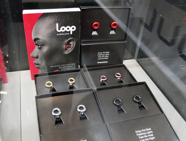 画像: ▲LOOPブランドのイヤープラグ(耳栓)。普通のイヤホンのように装着する。輪っかの部分に音を取り込む切り欠きがあり、そこから取り入れた音を約20dB音圧のみを下げて耳へ届けてくれるという