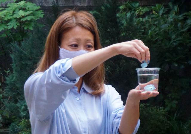 画像: E8 Sportの防水性能を確認してもらうために、コップに張った水の中に入れるというデモも実施