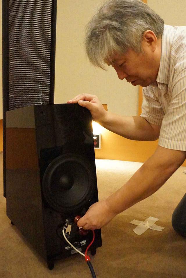画像: ←リア部のウーファーと入力端子を確認する三浦氏