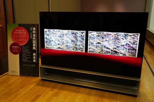 画像: ▲「洛中洛外図屏風 舟木本」の「8K文化財プロジェクト」データによる8K映像を8K有機ELディスプレイにて表示したところ。本物に比べてかなり鮮やかに仕上げられており、そのことについて担当者に聞いてみると、「完成当時の色彩を、金箔の色味を元に再現しているため」とのことだ