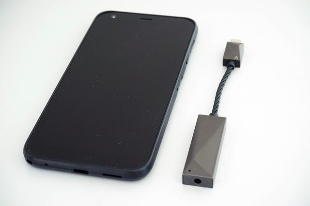 画像: 5.65インチ画面を備えたAndroidスマホの横に置いて撮影してみた。コンパクトなことがおわかりになるだろう