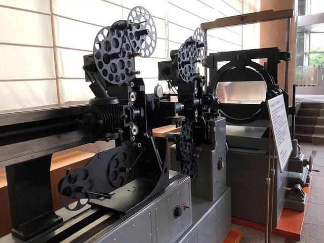 画像: 試写が行われた五反田・イマジカのロビーに展示されている「エリアルイメージ特殊合成機」。制作されたばかりの1966年、『大魔神怒る』では武神像が湖を割って進む有名なカットのオプチカル合成で使われている