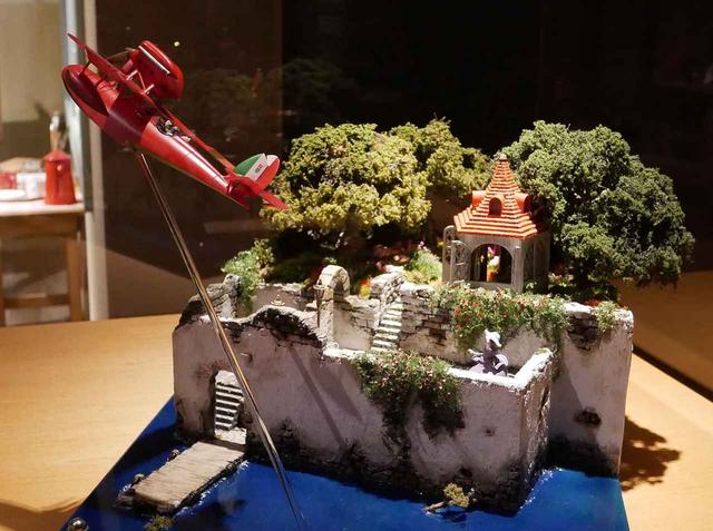 画像: ホテルアドリアーノの上空を飛ぶサボイアS-21の様子も再現。ちゃんとジーナの姿も再現されています © 1992 Hayao Miyazaki/Studio Ghibli, NN