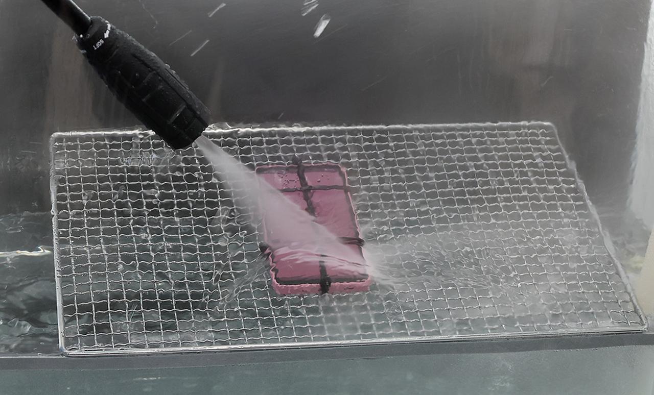 画像: 発表会では、防水性の高さを示すべく、高圧洗浄機で水をかける、というデモを実演