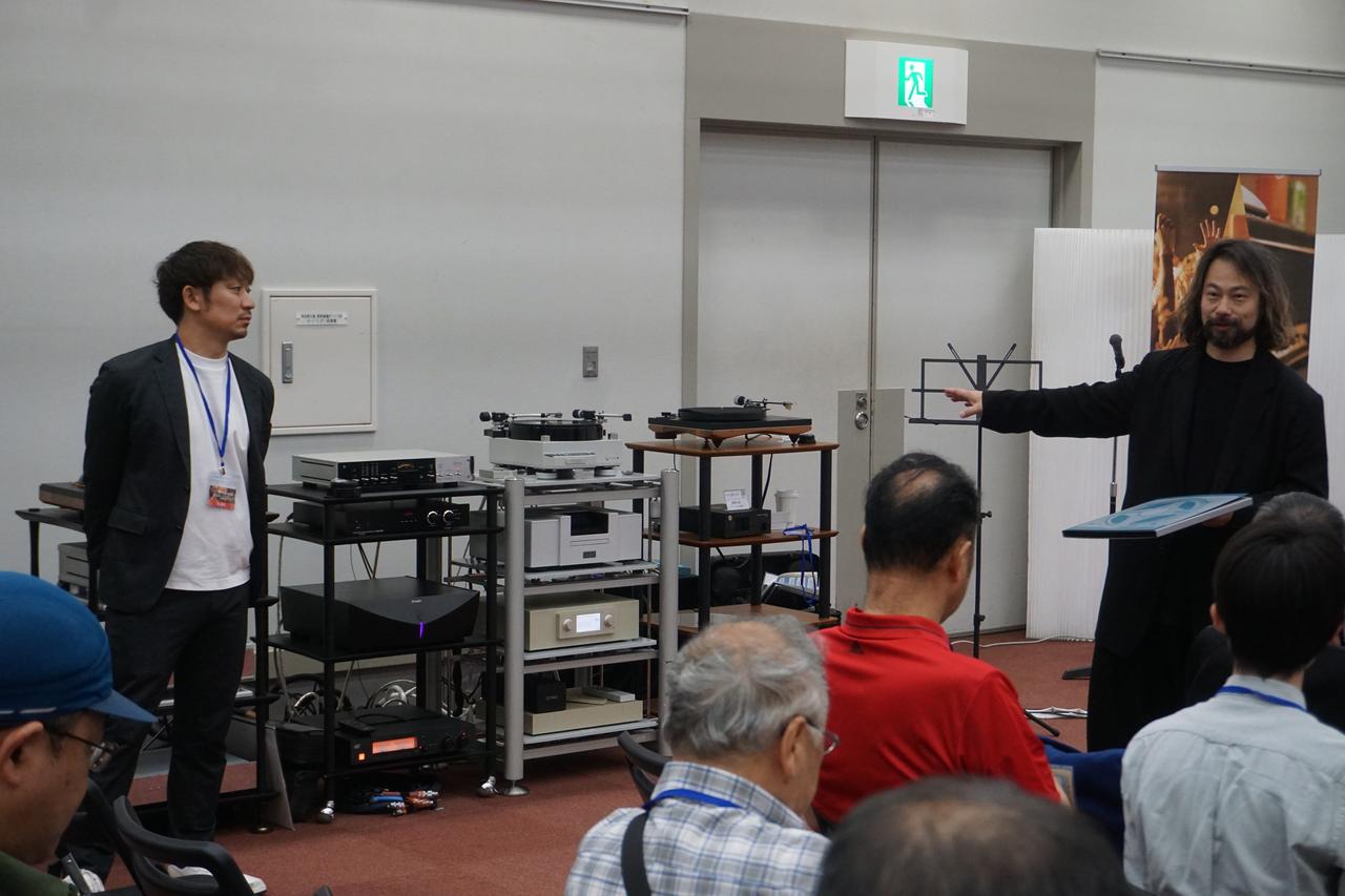 画像: ミドルクラスカートリッジ対決の様子。DS AUDIO「DS003」とOrtofon「SPU GTX E」の比較試聴が行われ、デジタルストリーム代表の青柳社長(写真左)とOrtofon代表の坂田社長(写真右)が自社製品を来場者へプレゼン