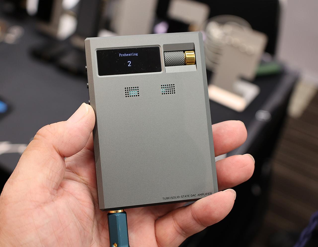 画像: ▲【コペックジャパン】Cayin(カイン)ブランドの新製品「RU9」の展示・試聴を提供していた。いわゆるポータブルDAC・アンプで、従来のようなドングル型から、バッテリーを内蔵したことで、スクエアなDAP的なデザインになっている。ユーザーからは、スマホのバッテリーの持ちが気になるという声が寄せられたそうで、バッテリー内蔵仕様にしたとか。最近のトレンドになっている真空管を搭載しており、小型化のためにNutubeをセレクトしている。BTレシーバー機能も装備。出力は3.5mm、4.4mm、光(3.5mm)。切り替えスイッチで、バスパワー駆動も可。7月7日発売で、価格は¥86,900(税込)。フジヤでは発売記念で¥79,200(税込)と表示されている、スリットから見える光が真空管のもの