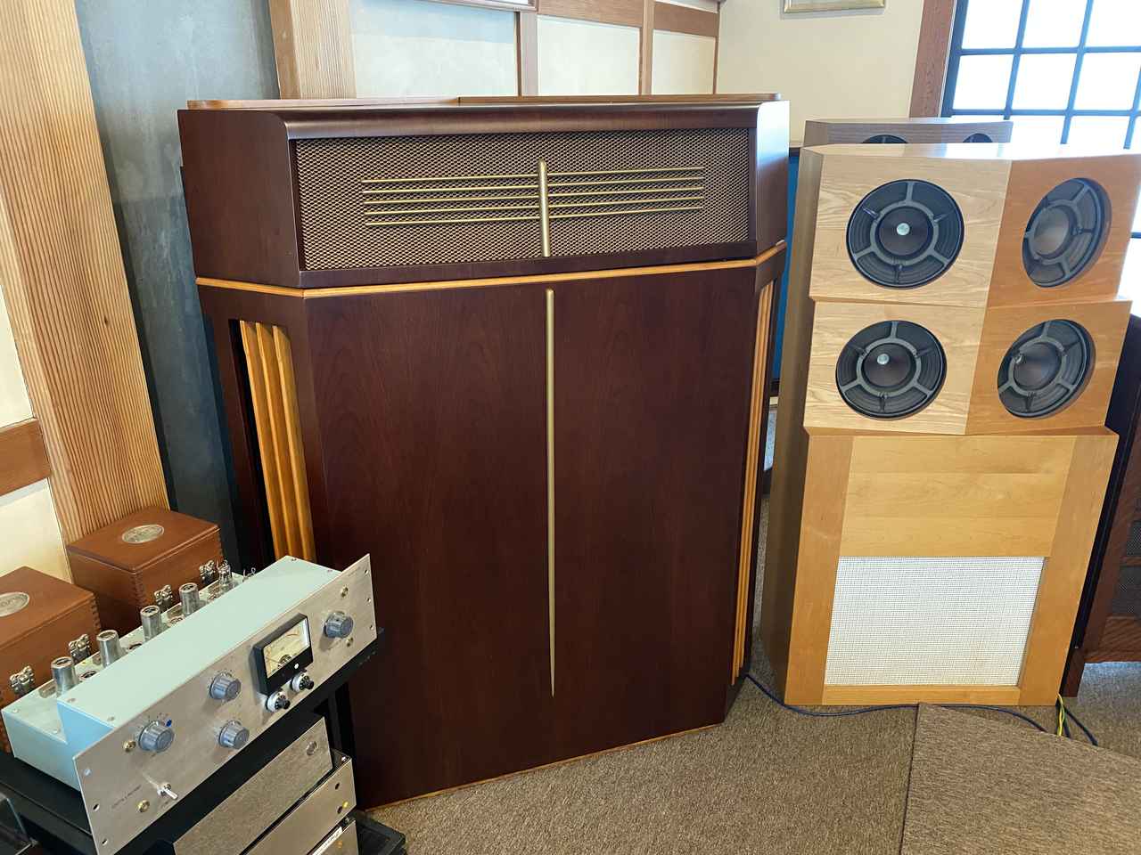 画像: 是枝氏リスニングルームのバイタボックスCN191クリプシュホーンリプロデューサー。コンシューマー用大型モデルとして、LPレコード登場直前の1947年に発表された。正面の平面部の横幅は80cm。フロントローディング・フォールデッド・コーナーホーン型で、38cm口径ウーファー（K15/40など）と7.6cm口径のコンプレッションドライバー＋ホーン（S2＋CN157）による2ウェイである。10インチ口径フルレンジ、グッドマンAXIOM80を4基並列にしたシステムが右に見える。