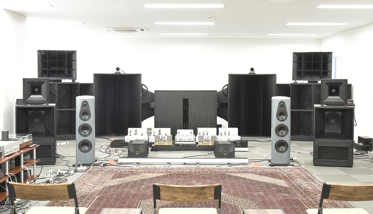 画像: 和佐氏のリスニングルーム。3つの大型・励磁型ホーンシステムが構築される。中央にセットされた復刻16AホーンとGIP555×2基／chを軸としたシステムの中高域アンプとしてウエスギ・パワーアンプ2機種を組み合わせて試聴した。写真は300Bプッシュプル・モノーラルのウエスギU・BROS330AHを結線した状態。その後方にはシルバトーン製とGIPラボラトリー製のアンプが見える。16A＋555システムは中央のボックス型エンクロージュアに収めたGIP4165ウーファー×4基を3Dシステム的に追加した構成で、GIP4165ウーファーはGIP製6550プッシュプル・モノーラルパワーアンプで駆動される。手前に見える半導体型パワーアンプのリンKlimax Solo 800は、写真には写っていないJBLパラゴンを主に鳴らしている。