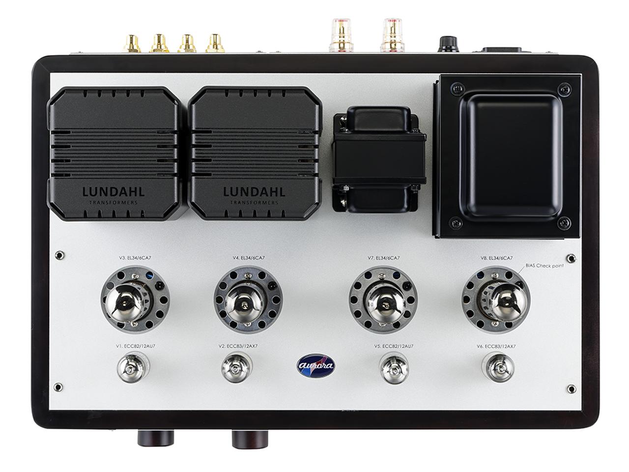 画像: 全段真空管で回路を構成するインテグレーテッドアンプ／パワーアンプは同社初。初段は12AX7パラレルで、12AU7によるムラード型位相反転段、EL34プッシュプル出力段の構成。出力段UL接続・自己バイアス動作で31W＋31Wの出力を得る。出力管ソケット部のテスターポイントでバイアス電流のモニターが可能だ。リア側には、カスタムメイドの国産電源トランスとチョークコイル、瑞ルンダール製の出力トランスを配置。22mm厚の無垢カエデ材フレームと4mm厚アルミニウムの天板と組み合わせることで、シャーシ全体の剛性を高めている。セレクターとボリュウムのノブも木製。