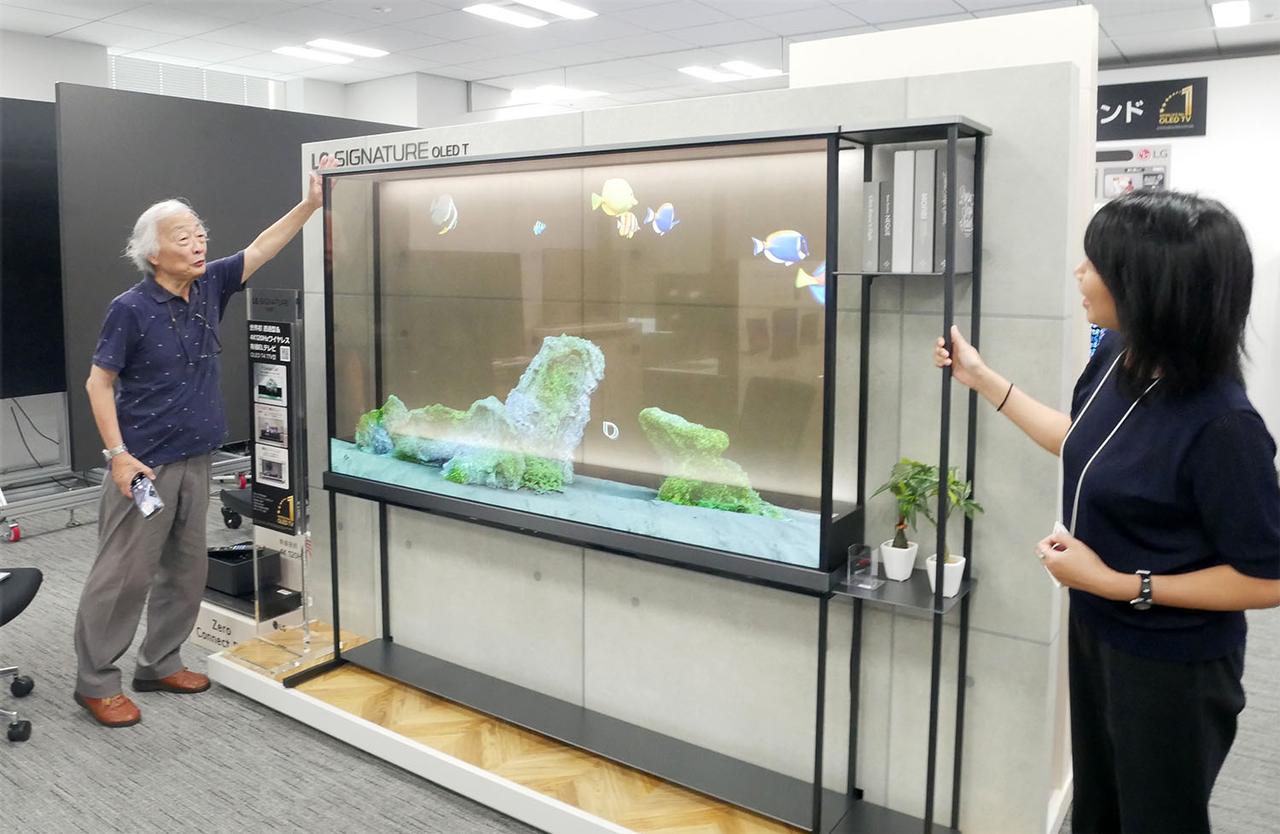 画像: 透明有機ELパネルに興味津々の麻倉さん