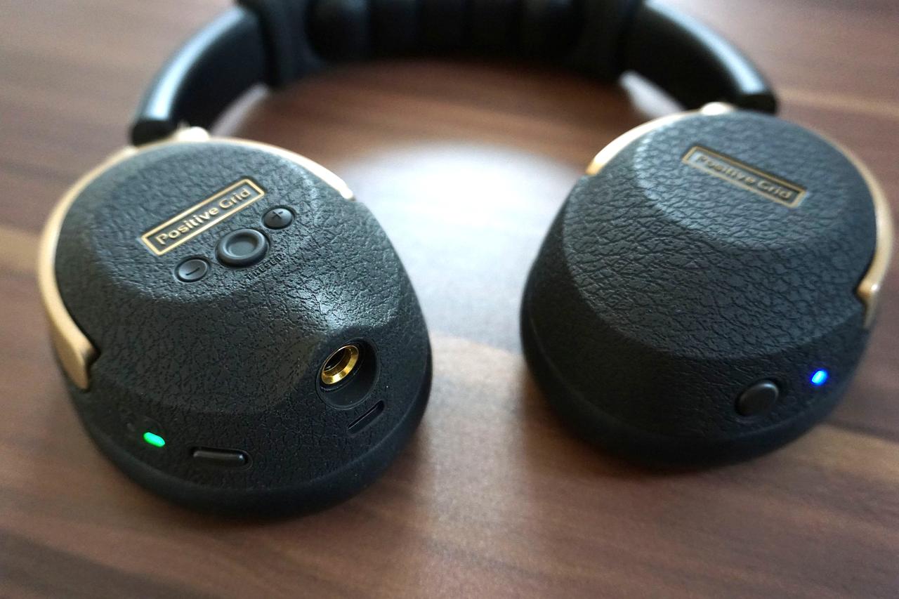 画像: 「Spark NEO」。ギターに付属のトランスミッターをつなぐことによりBluetooth接続してワイヤレスで演奏可能(Bluetoothのオン・オフは右側のハウジングに点灯している青いライトで確認できる)。左側のハウジング下部のジャックにシールド(ケーブル)をつなぐことで有線接続可能