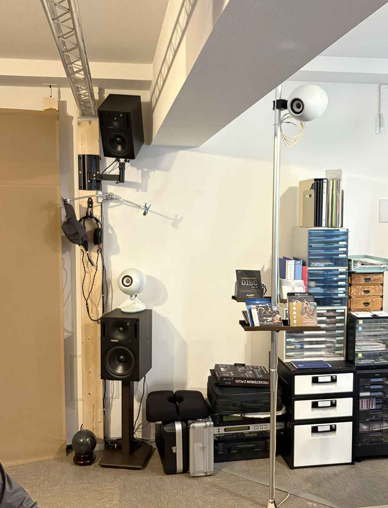 画像: ジェネレックの「1030A」ハイトスピーカーは2✕4用用のツールを使った突っ張り板に取り付けている。ドルビーアトモス用のイクリプス「TD308II」は写真スタジオ用の突っ張り棒を使っているとのこと