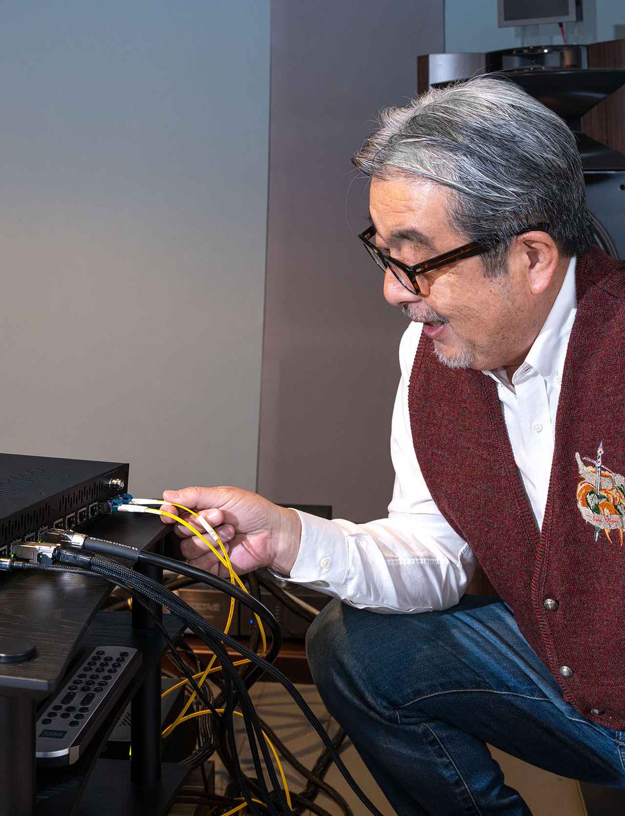 画像: 光LANケーブルを確認する山本さん。ケーブル自体は太さ5mmほどということで、これなら壁沿いに這わせることができるかも、と真剣に導入を検討されていました