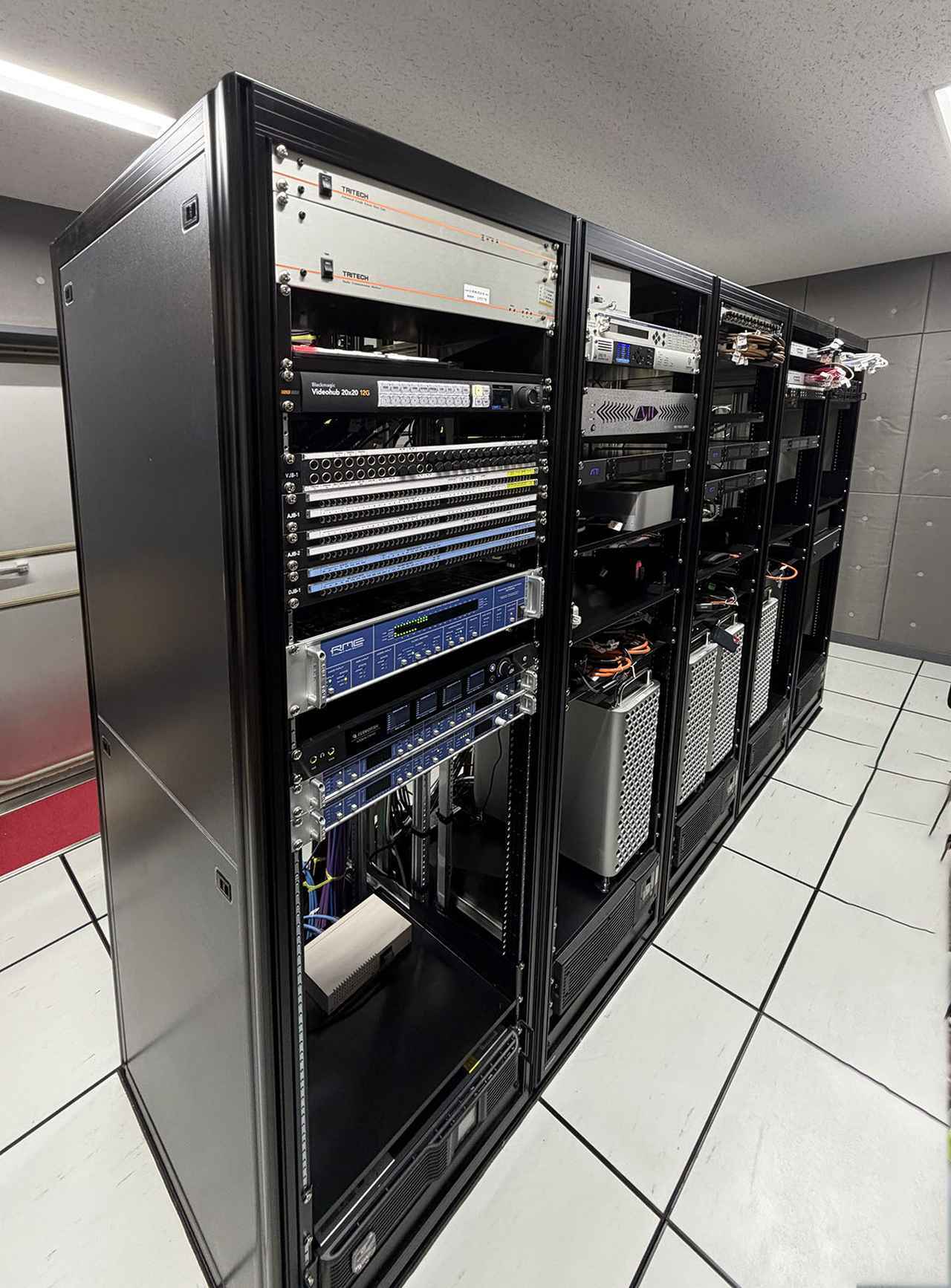 画像: コンソール卓にはアビットのS6が採用されている。マシンルームには4台のPro Toolsとドルビーアトモス用の5台のPCなどが並んでいる